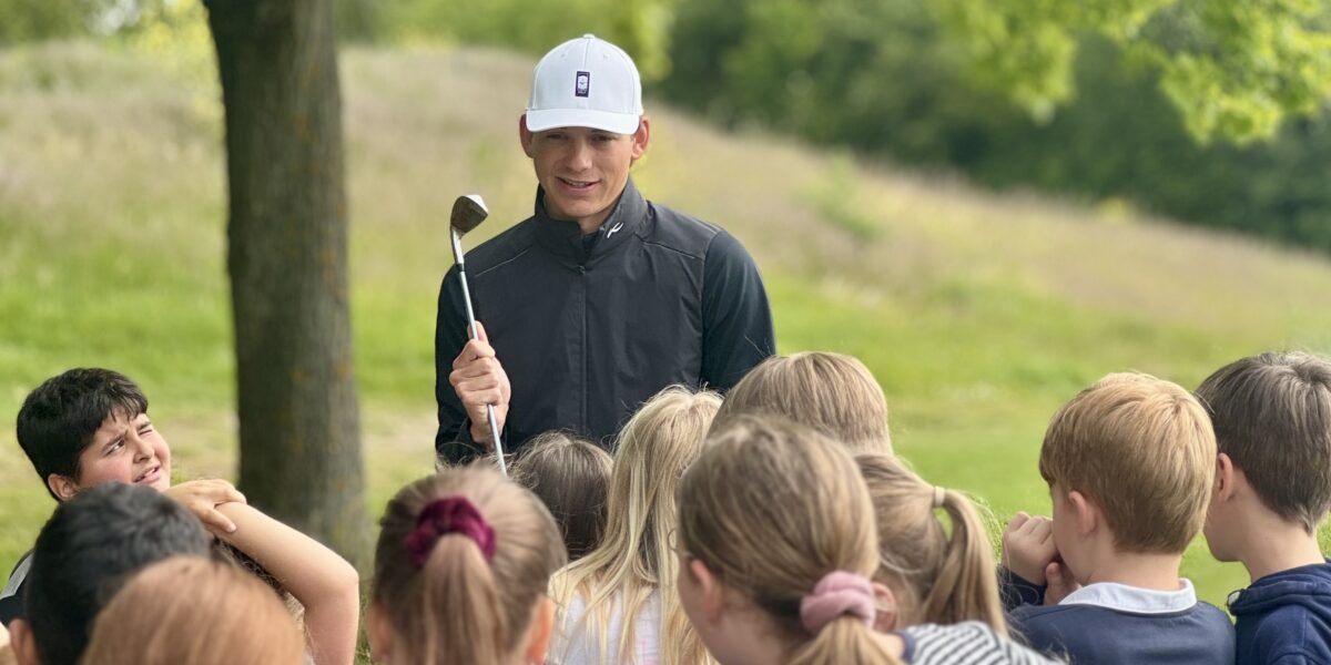 Luc Weyell, Golftrainer des Golfclubs, erklärt einer Gruppe von Kindern den Golfsport